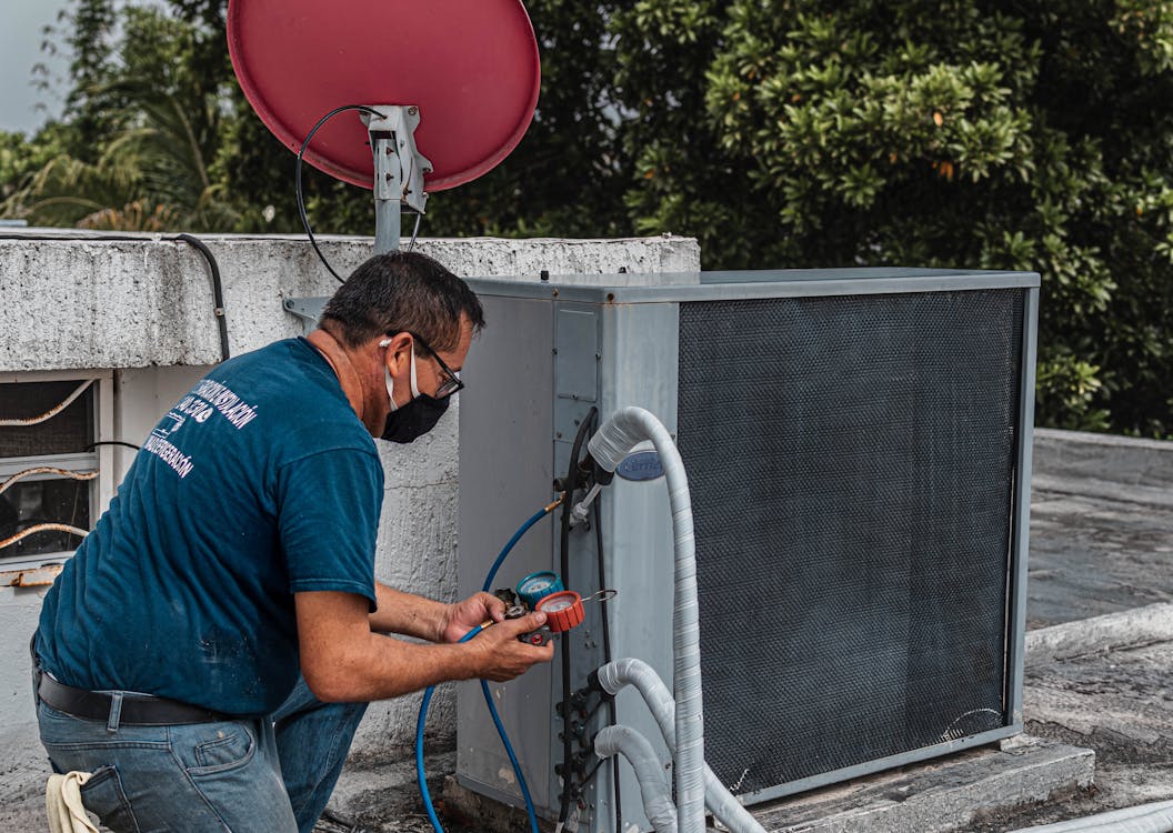 HVAC technician diagnosing a heating system with manifold gauges